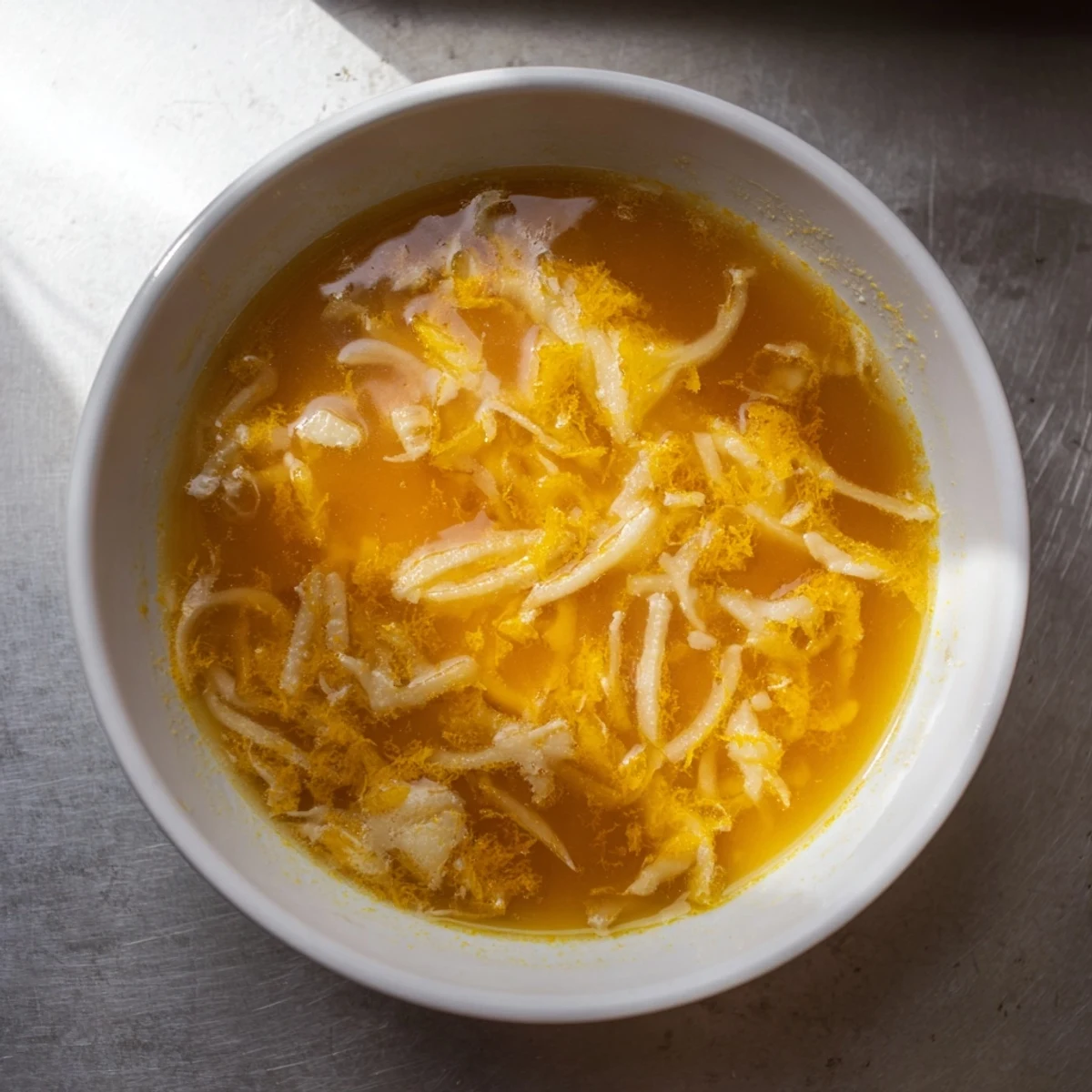 Melting Gruyère bubbles atop rich German Cheese and Onion Beer Soup, a creamy, savory delight.