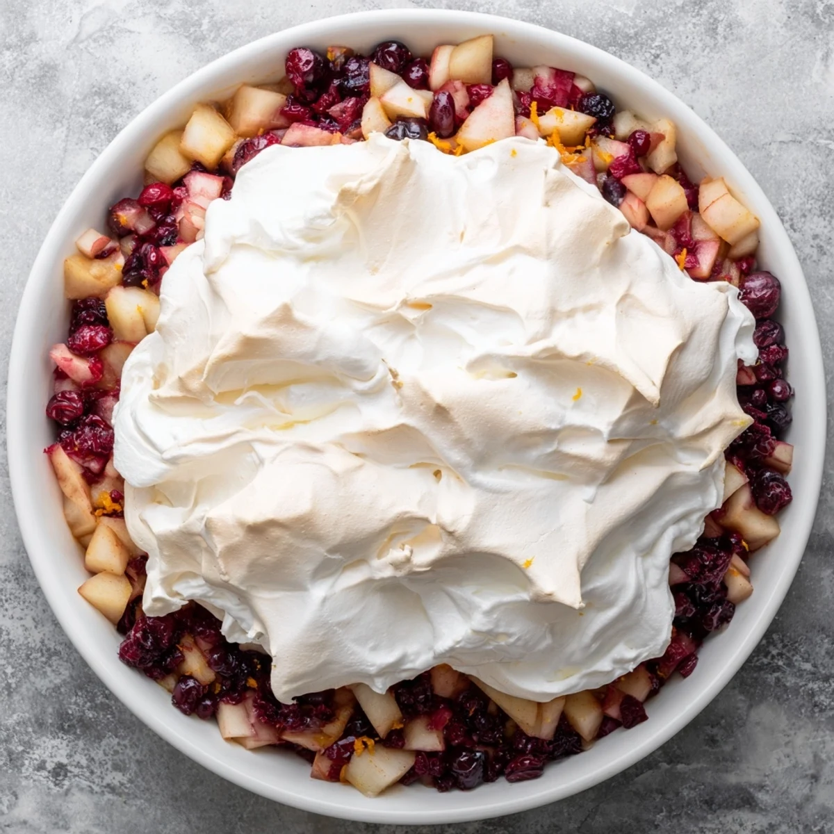A picture showcasing the festive Cranberry and Pear Snowscape dessert with fluffy meringue peaks.