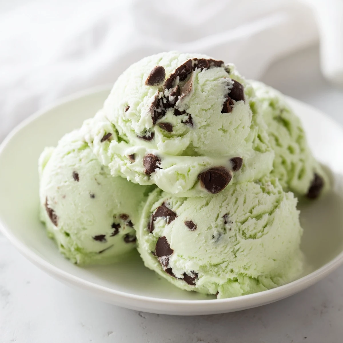 Creamy, homemade mint chocolate chip ice cream, swirled with cool green and dark chocolate chips.
