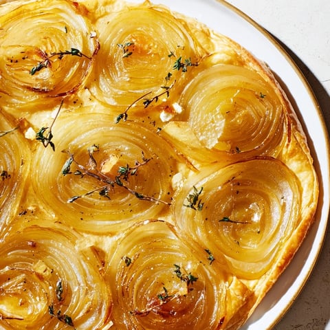 Golden, flaky Tarte Fine with Onions & Thyme, showcasing the caramelized onions and crispy pastry crust.