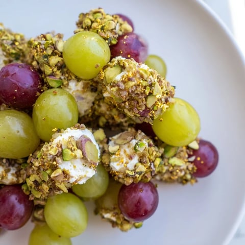 Sparkling Grape Cluster Appetizer with jewel-toned grapes coated in cheese and shimmering nuts.