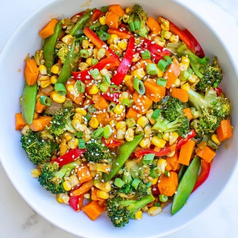 This easy Colorful Vegetable Stir-Fry showcases colorful, steaming mixed veggies, perfect for a quick vegan meal.