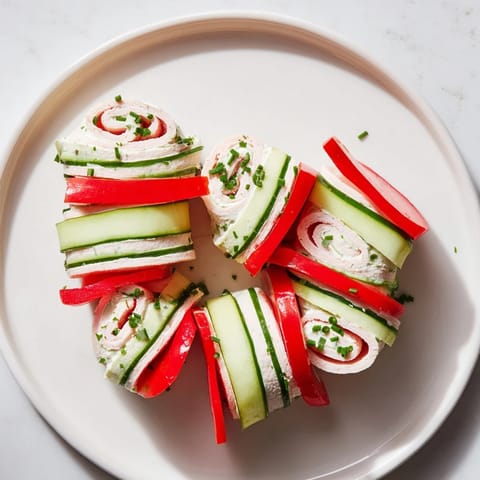 Simple and delicious, these vibrant turkey roll-ups are stacked on a plate, ready to enjoy.