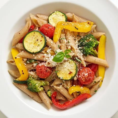 Die Kombination aus bunten, gebratenen Gemüsestücken und den goldbraunen Nudeln macht das Pasta Primavera sommerlich frisch und einladend.