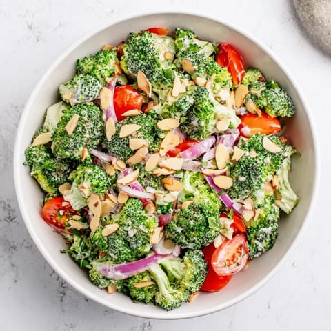 Geröstete Mandeln und frische Petersilie garnieren diesen erfrischenden Garlic Parmesan Broccoli Salad im Glas.