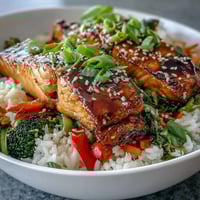 Teriyaki Salmon Bowl mit glasiertem Lachs, krossen Gemüsestücken und Duftreis für ein gesundes Abendessen.