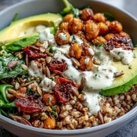 Nahrhaftes Ancient Grains Bowl mit Farro, Quinoa, Kichererbsen und Avocado.